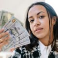 Black woman holding cash, representing funding opportunities for August 2025 grants in New York